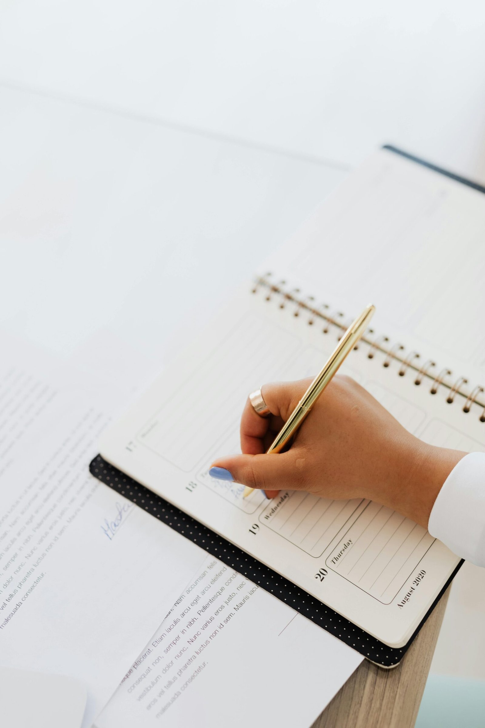 Elegant hand writing plans in a notebook with a pen, perfect for organization themes.